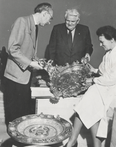 Drei Personen begutachten Kunstgegenstände